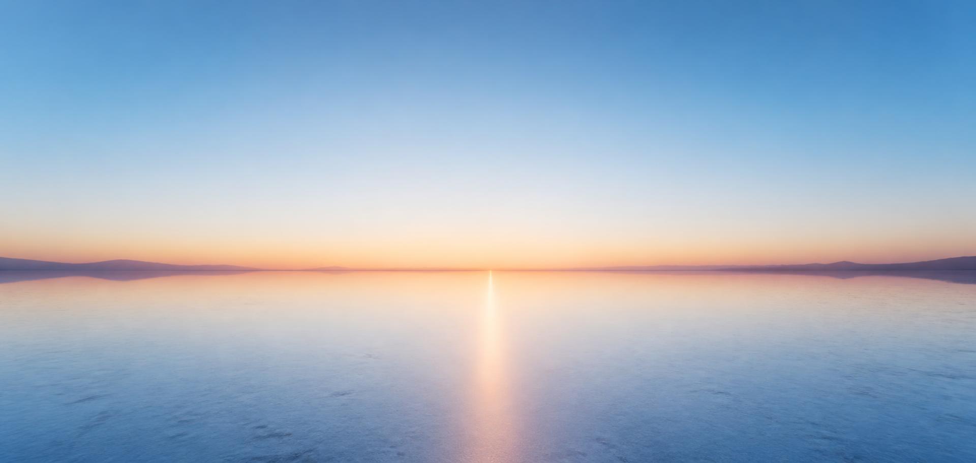 Wide dawn landscape with a low horizon and first warm light